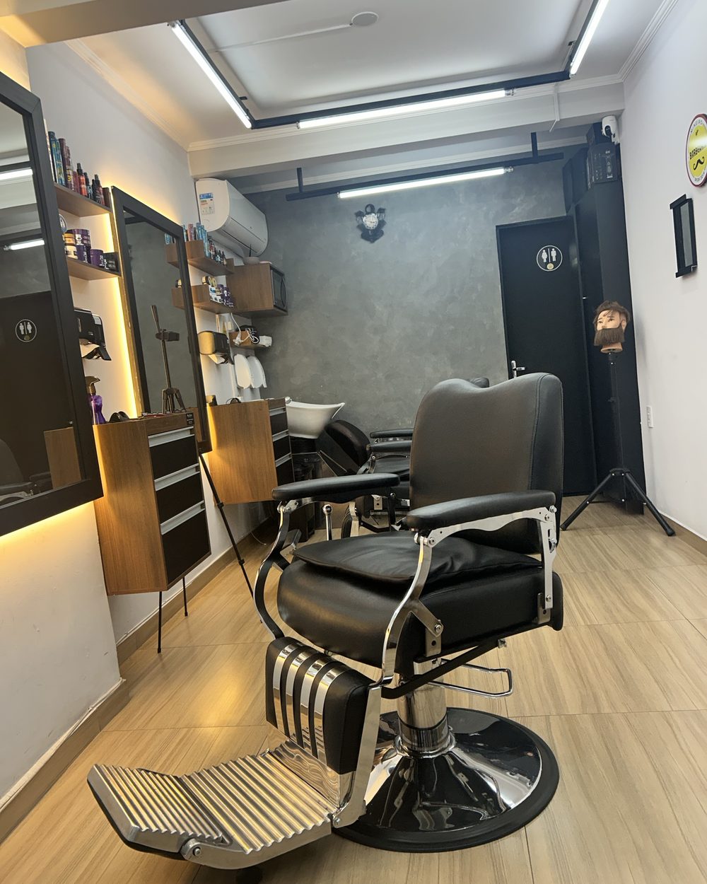 Cadeira de barbeiro profissional da Mineiro Barbearia, com parede de cimento queimado ao fundo